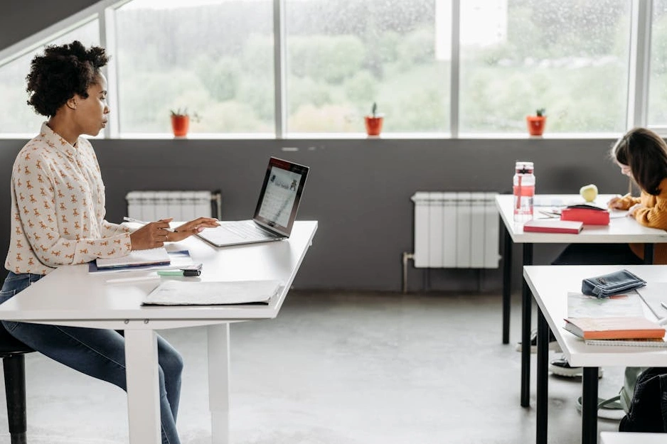 Uśmiechnięty uczestnik kursu pracujący na laptopie.